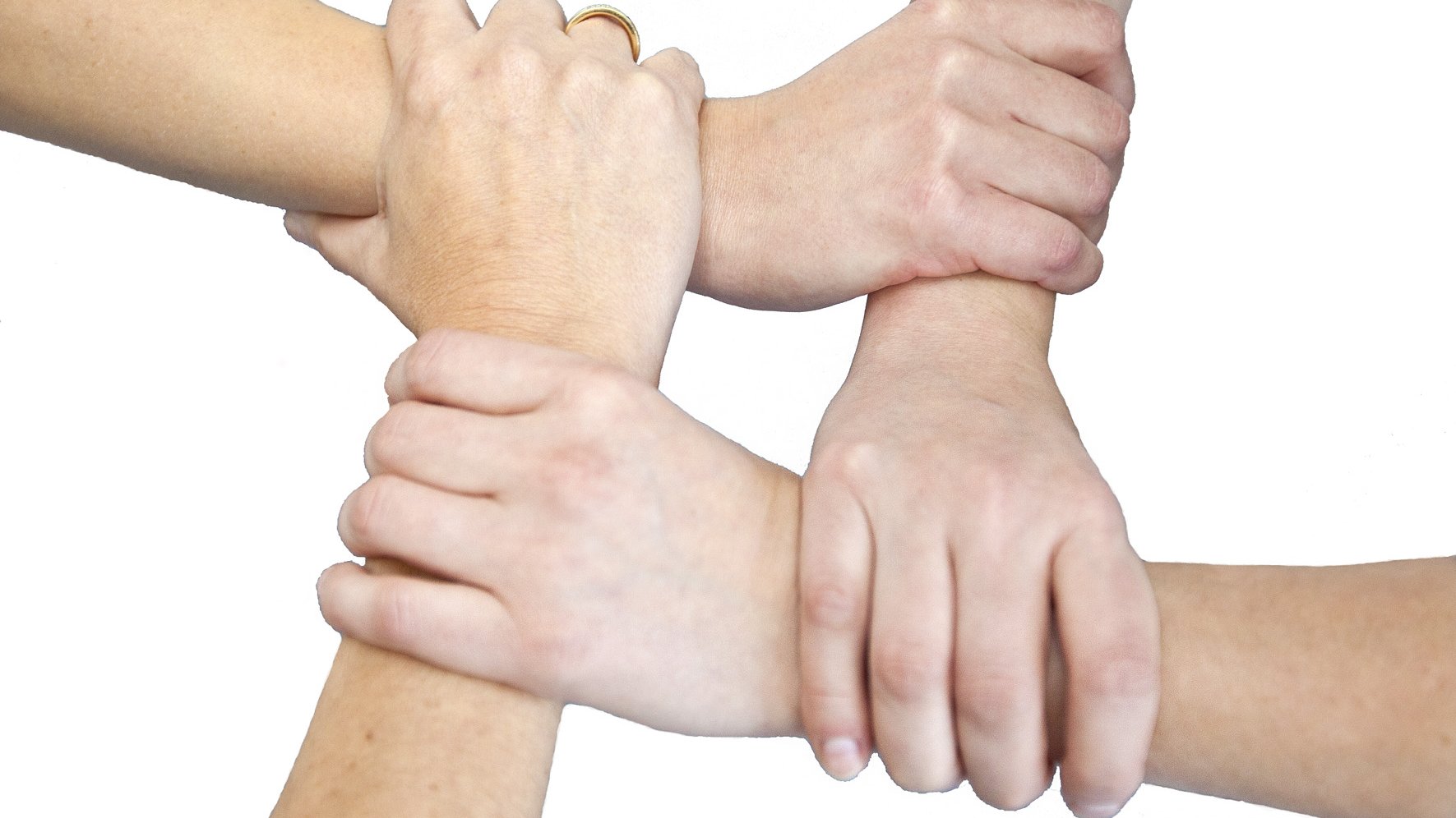 Vier Hände die sich gegenseitig am Handgelenk greifen.