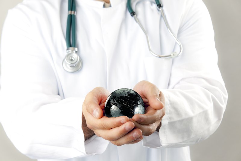 picture of medical doctor holding a ball resembling the world