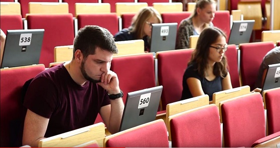 Studierende bei einer Prüfung im Hörsaal mit einem Laptop vor sich