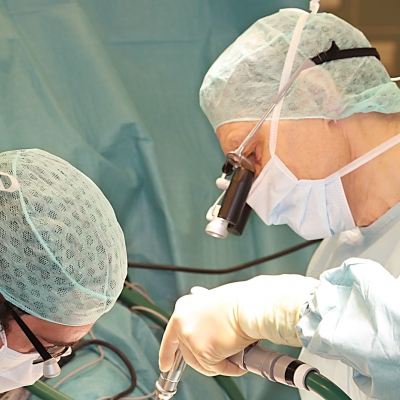 Zwei Ärzte operieren mikrochirurgisch