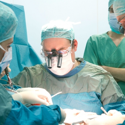 Bildausschnitt aus dem OP - zwei Ärzte operieren.