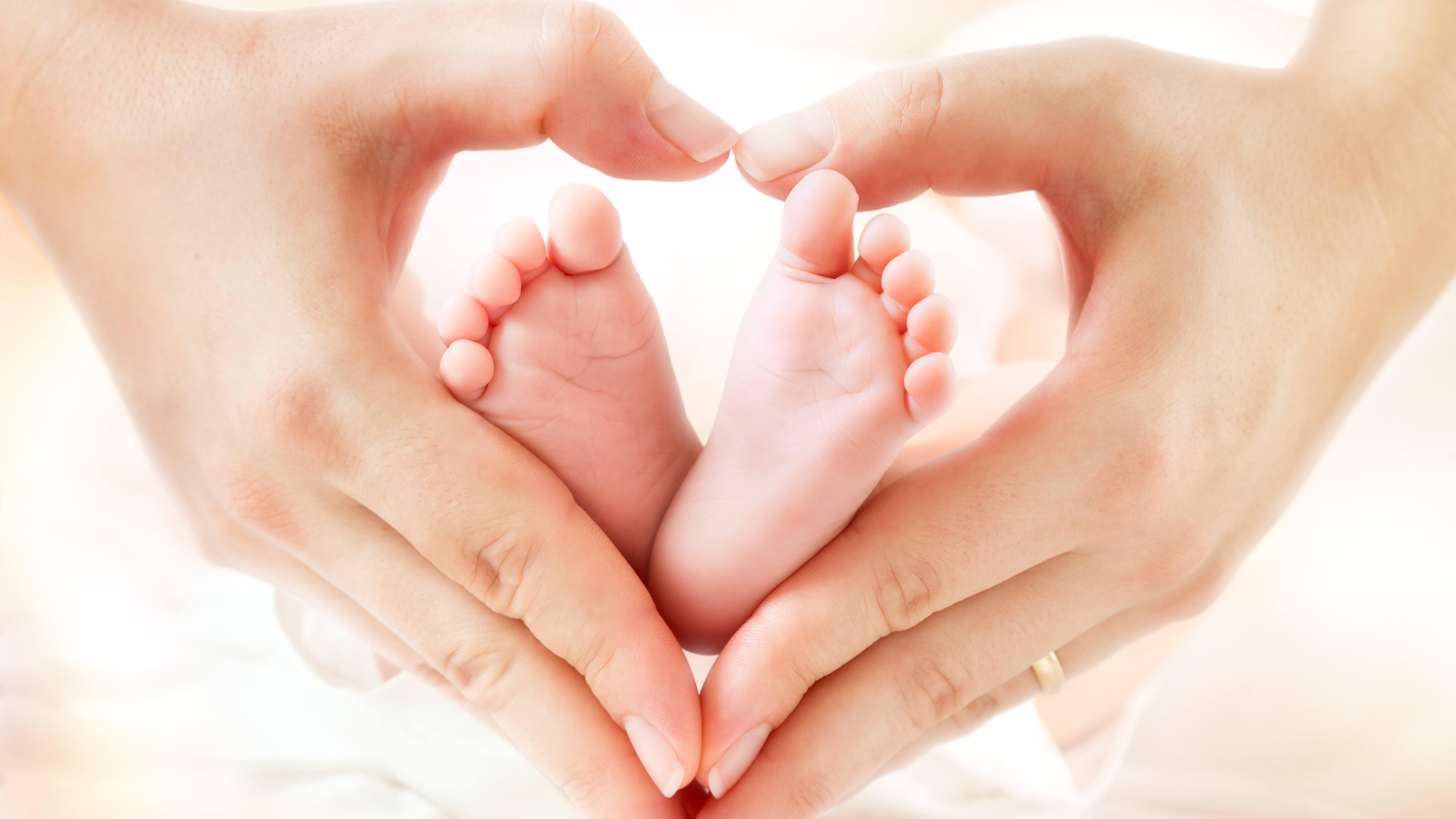 Babyfüße werden von Elternhänden gehalten