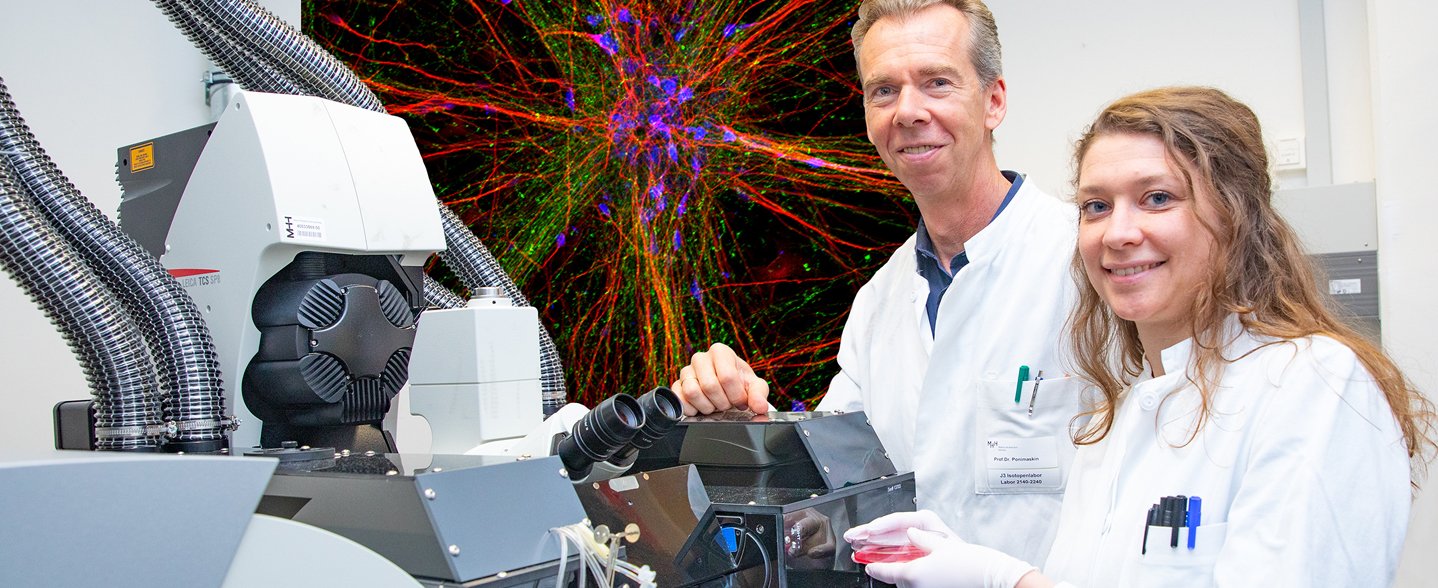Professor Dr. Evgeni Ponimaskin und Dr. Josephine Labus stehen vor einem Lasermikroskop im MHH-Institut für Neurophysiologie. 