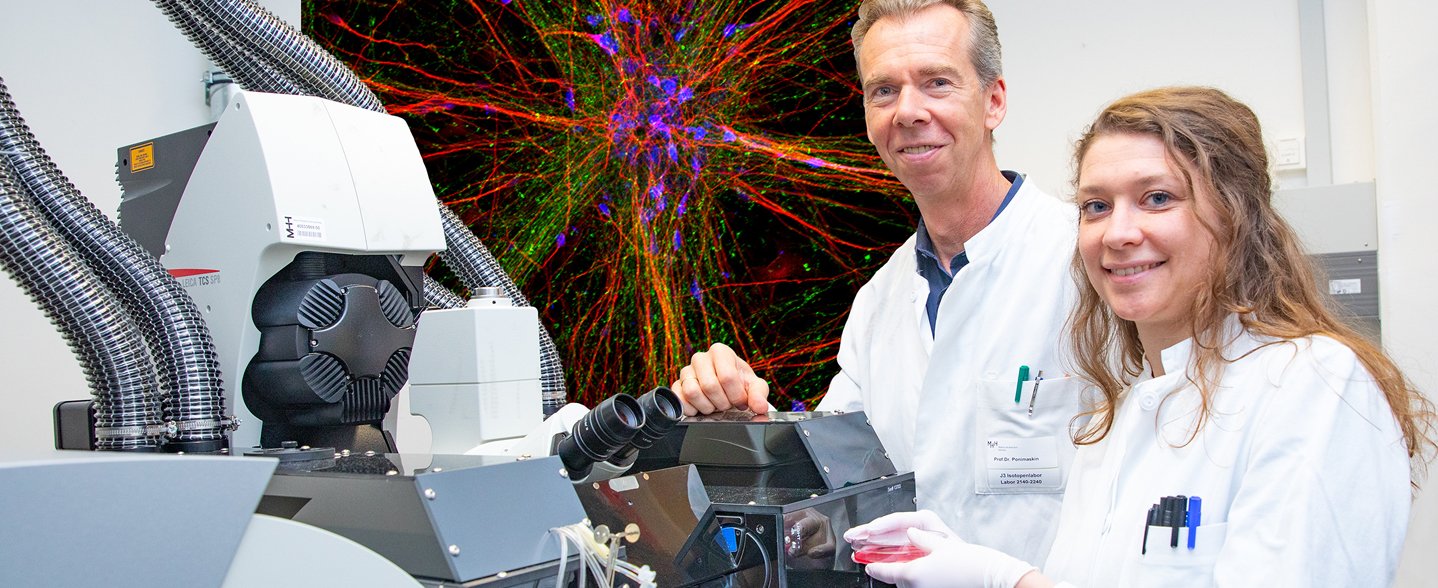 Professor Dr. Evgeni Ponimaskin und Dr. Josephine Labus stehen vor einem Lasermikroskop im MHH-Institut für Neurophysiologie. 
