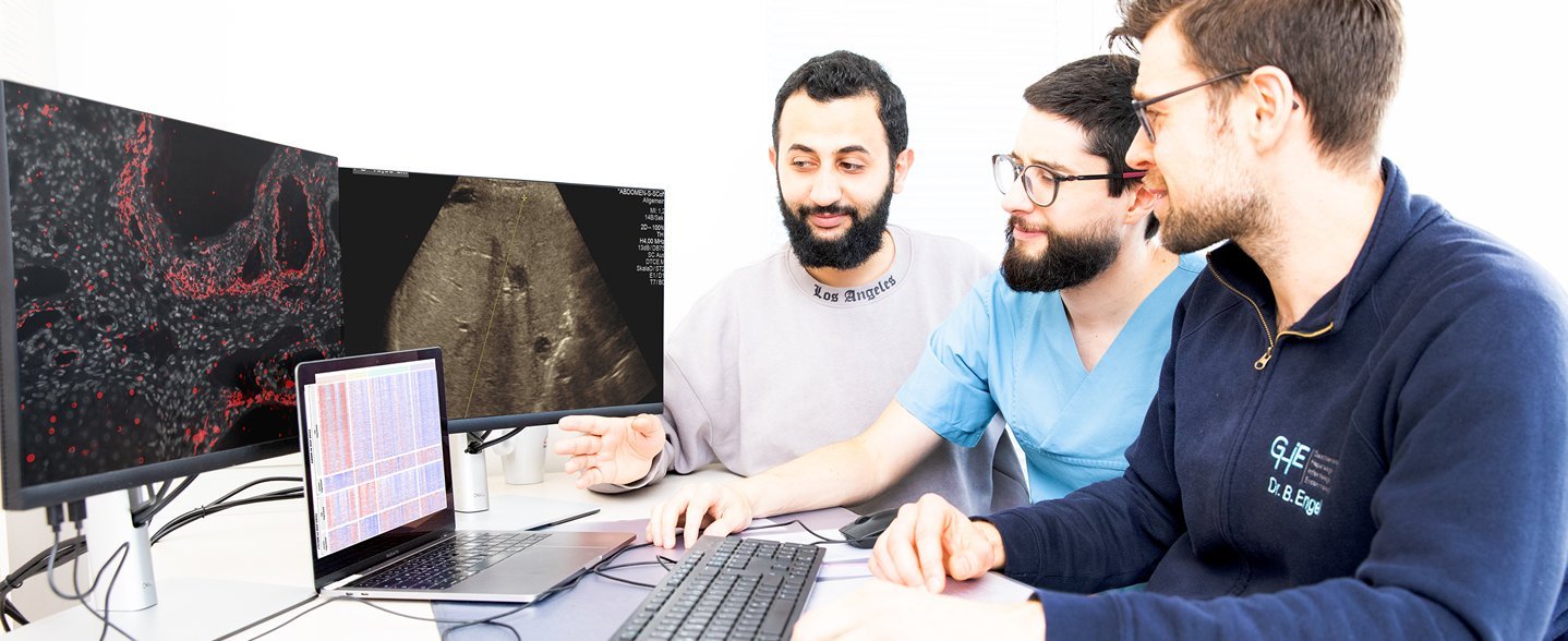 Ahmed Alaswad, Alejandro Campos-Murguia und Dr. Bastian Engel sitzen vor zwei Monitoren mit mikroskopischen Abbildungen.