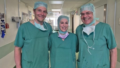 Ein Chirurgie-Team, bestehend aus zwei Männern und einer Frau. 