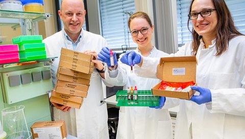 Professor Dr. Georg Behrens, Research Associate Anne Cossmann (center) and Professor Dr. Alexandra Dopfer-Jablonka present shipping boxes and blood sampling tubes. 