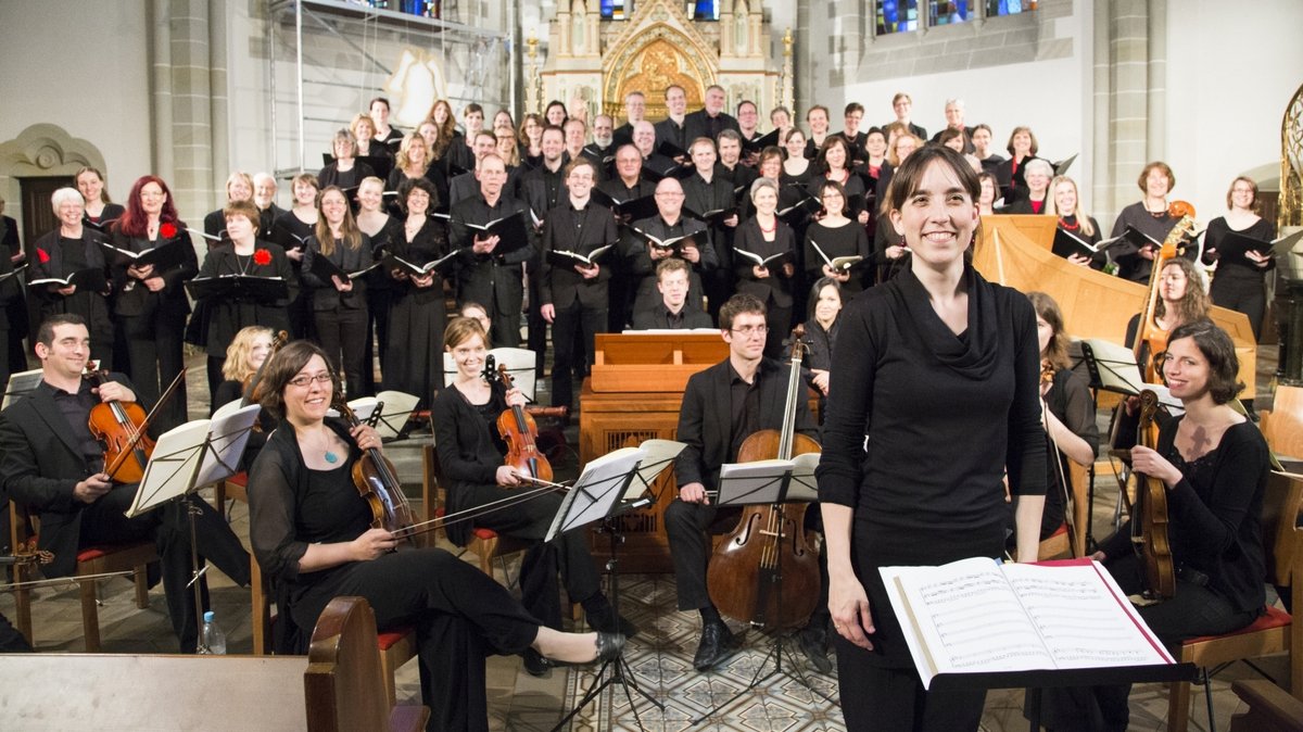 Das MHH-Symphonieorchester steht in einer Kirche vor dem Altar. 