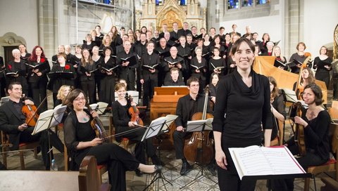 Das MHH-Symphonieorchester steht in einer Kirche vor dem Altar. 