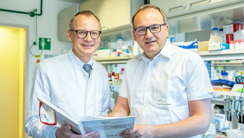 Professor Dr Heiner Wedemeyer and Professor Dr Markus Cornberg stand in a laboratory at the MHH Clinic for Gastroenterology