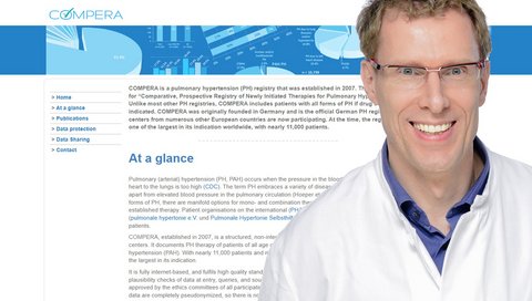 Professor Dr Marius Hoeper in a white doctor's coat in front of the enlarged homepage of the COMPERA Pulmonary Hypertension Register.