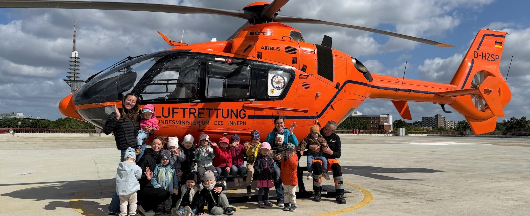 Kitakinder stehen vor dem Helikopter Christoph 4
