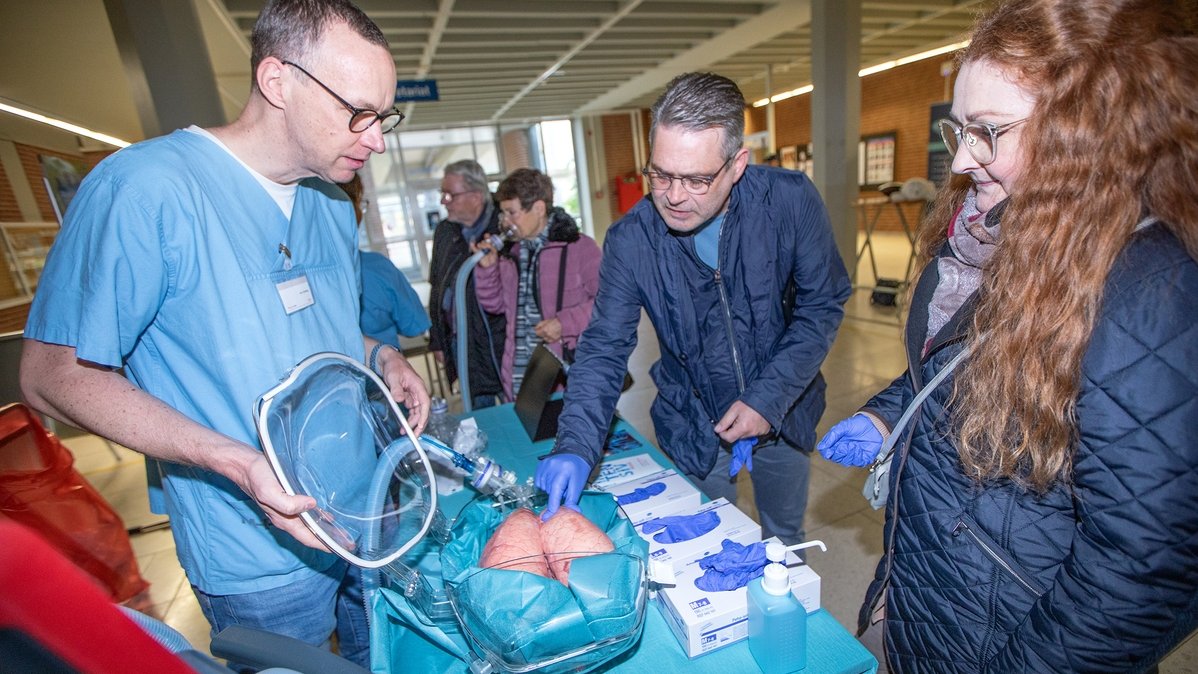 A ventilated pig's lung is touched by a visitor wearing protective gloves at the intensive care stand.