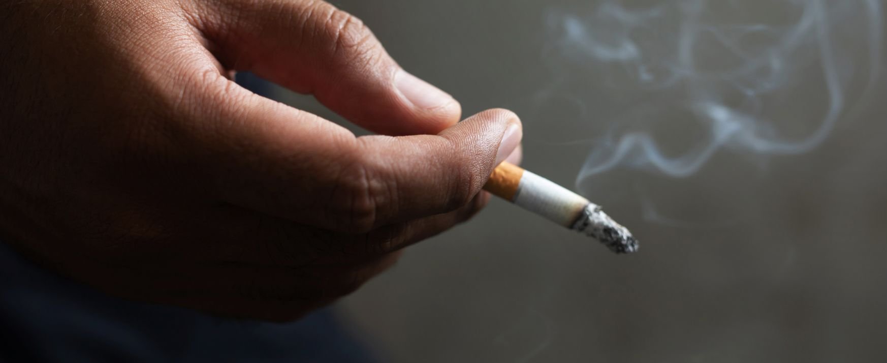 Hand mit rauchender Zigarette. 