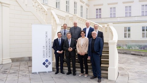 Gruppenbild mit Teilnehmenden des COFONI-Abschlusssymposiums auf einer Treppe vor dem Tagungszentrum Schloss Herrenhausen. 