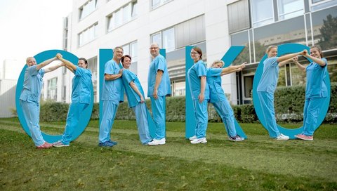 Pflegende bilden mit ihren Körpern den Schriftzug "ONKO"