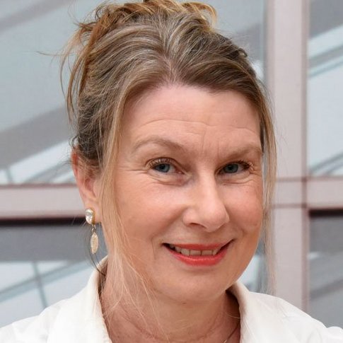 Porträtbild von Sophia Holthausen-Markou, die einen weißen Arztkittel trägt. 