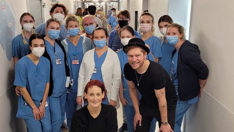 Johannes Oerding und Diane Weigmann mit Pflegekräften im Flur der MHH Kinderklinik. 