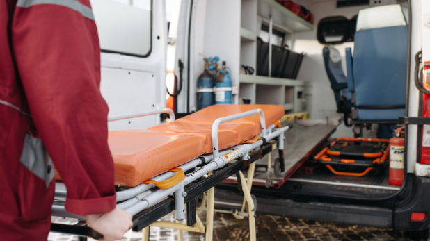 Eine leere Trage wird von einem Sanitäter in den Krankenwagen geschoben