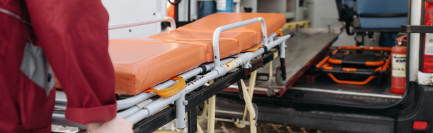 Eine leere Trage wird von einem Sanitäter in den Krankenwagen geschoben
