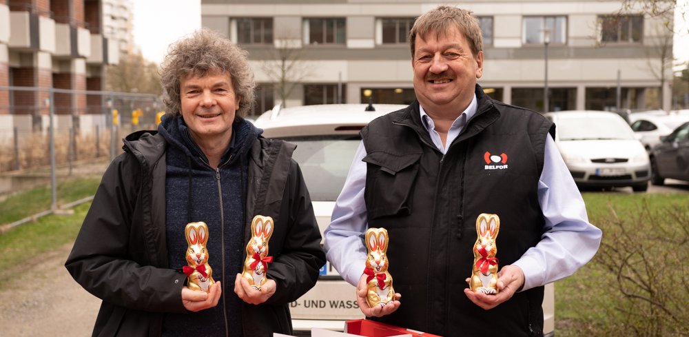 Dr. Schenke und Herr Brauckhoff schauen mit Osterhasen in der Hand in die Kamera