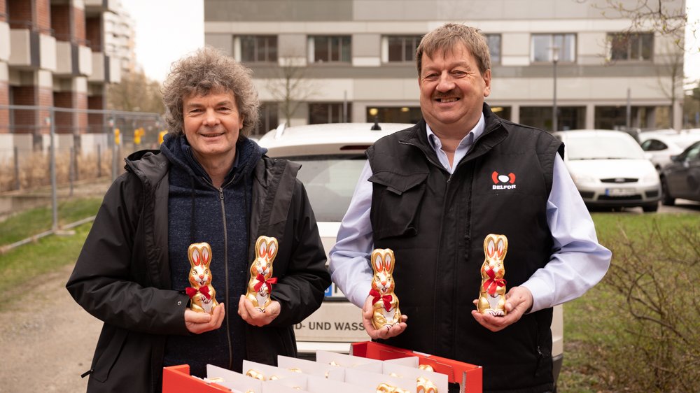 Dr. Schenke und Herr Brauckhoff schauen mit Osterhasen in der Hand in die Kamera