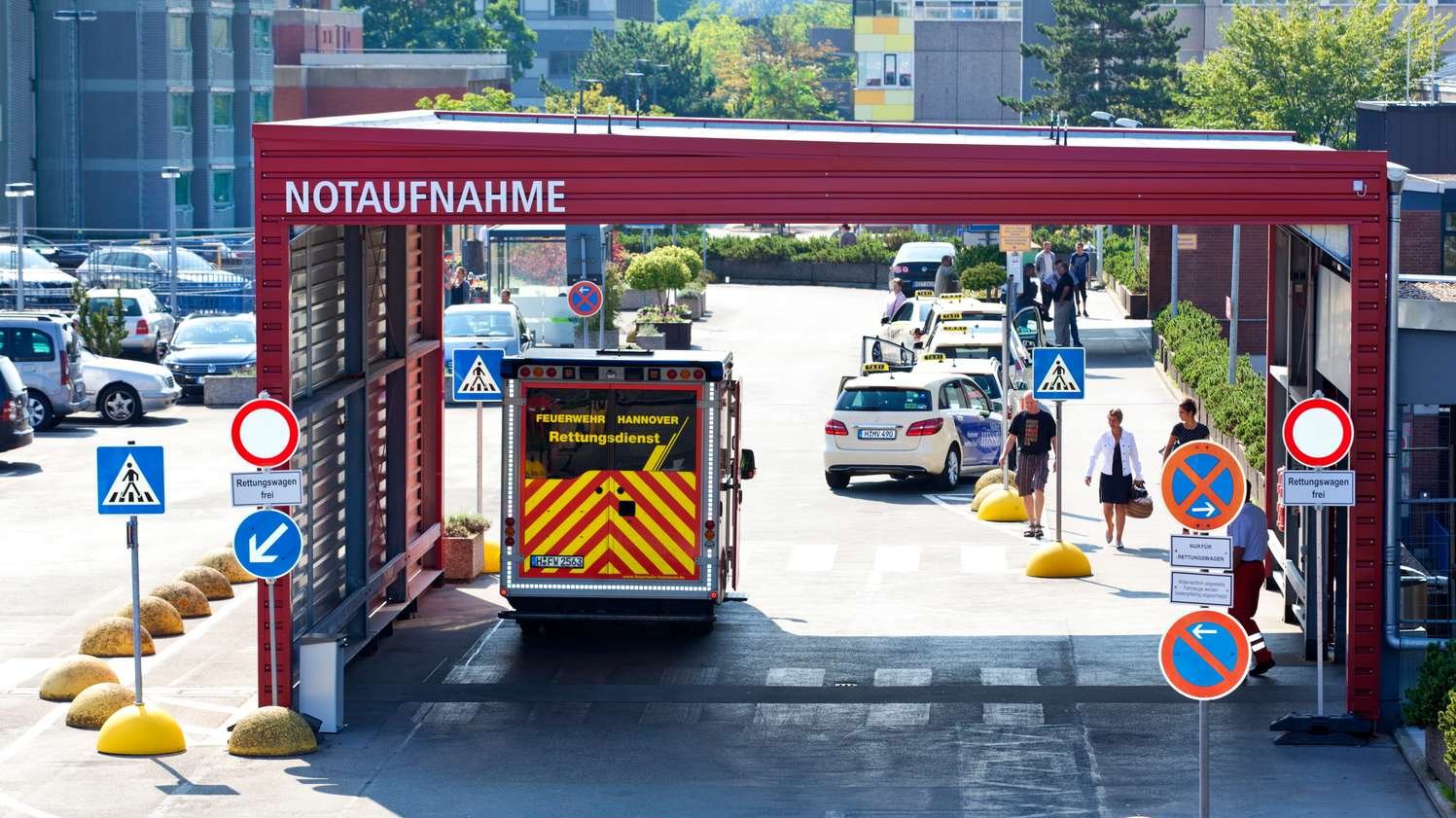 Vor der MHH Notaufnahme steht ein Rettungswagen, der von hinten zu sehen ist. 