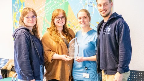 Die beiden Preisträgerinnen Dr. Natalie Palmaers und Laura Feuerhahn stehen mit Anna-Lena Herbach und Dr. Urs Mücke zusammen für ein Foto. 