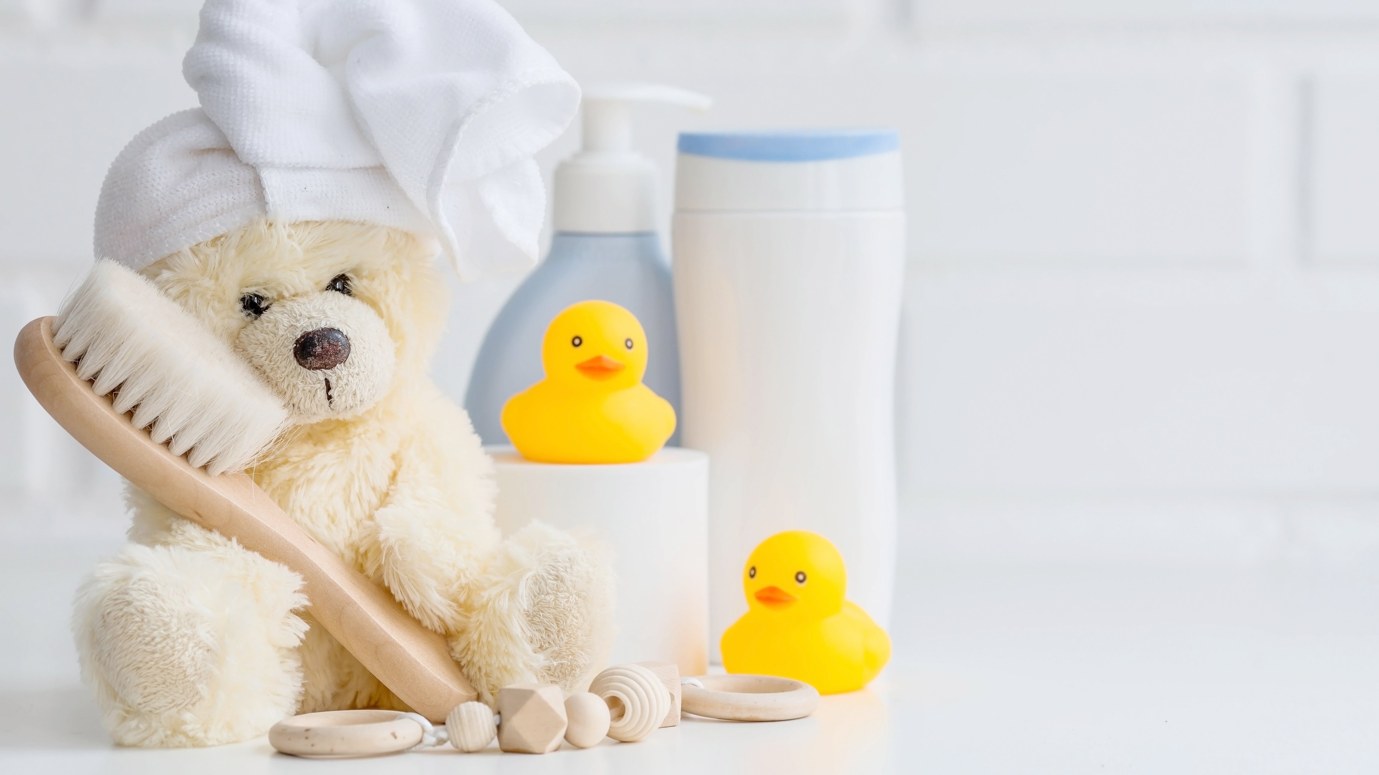 Adobe stock Pflegeutensilien für Babys werden von einem Teddybär gehalten