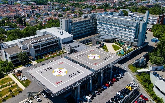 Im Vordergrund ist ein Hubschrauberlandeplatz zu sehen, im Hintergrund das Donau-Isar-Klinikum Deggendorf.