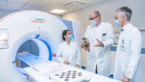 Professorin Dr. Kristina Imeen Ringe, Professor Wacker und Professor Lammert stehen rechts neben dem neuen CT-Gerät. 