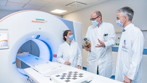 Professorin Dr. Kristina Imeen Ringe, Professor Wacker und Professor Lammert stehen rechts neben dem neuen CT-Gerät. 