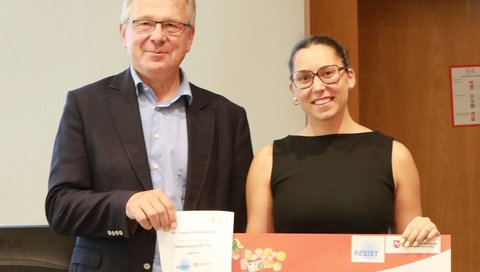 Judit Burgaya Ventura steht neben Prof. Dr. Reinhold Förster und hält einen großen Scheck in den Händen. 