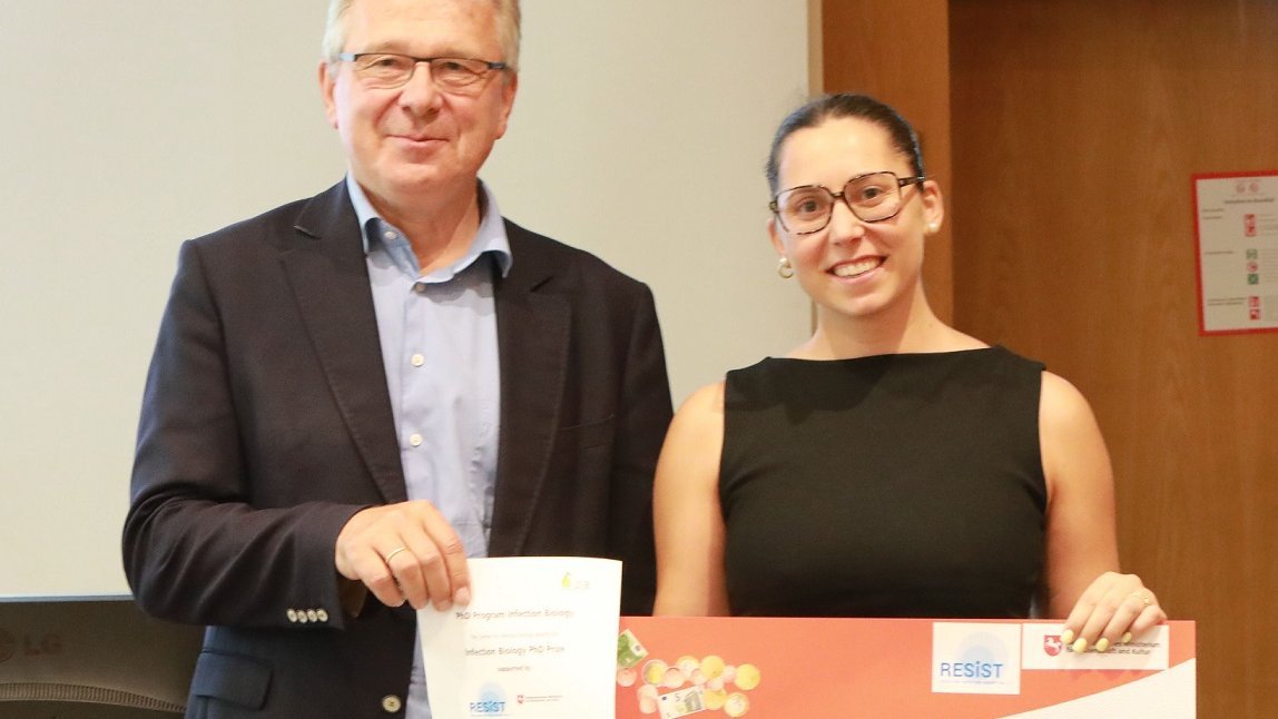 Judit Burgaya Ventura steht neben Prof. Dr. Reinhold Förster und hält einen großen Scheck in den Händen. 