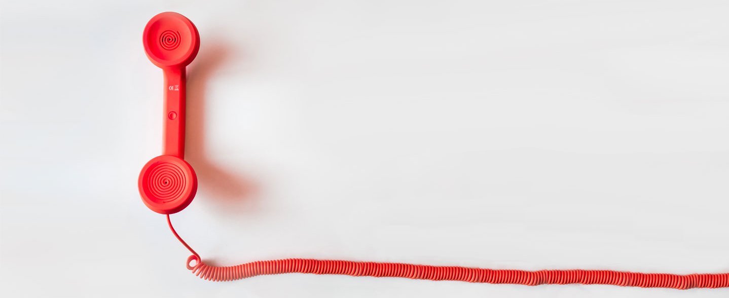 roter Telefonhörer mit nach rechts ausgerichteter rotem Spiralkabelrale