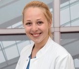 Porträtbild von Rieke Fielbrand, die einen weißen Arztkittel trägt. 