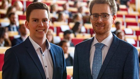 Die beiden Promotionspreisträger Dr. med. Christian Niehaus, und Dr. med. Liart Pollmann, stehen nebeneinander und halten ihre Promotionspreisurkunden in den Händen.