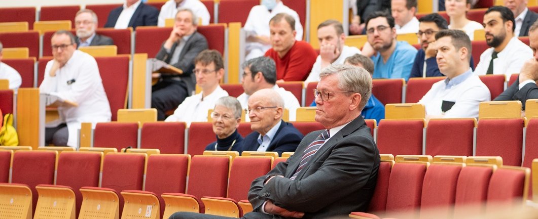 Im Hörsaal F der MHH sitzen viele Menschen in den Sitzreihen. In der ersten Reihe sitzt Axel Haverich.