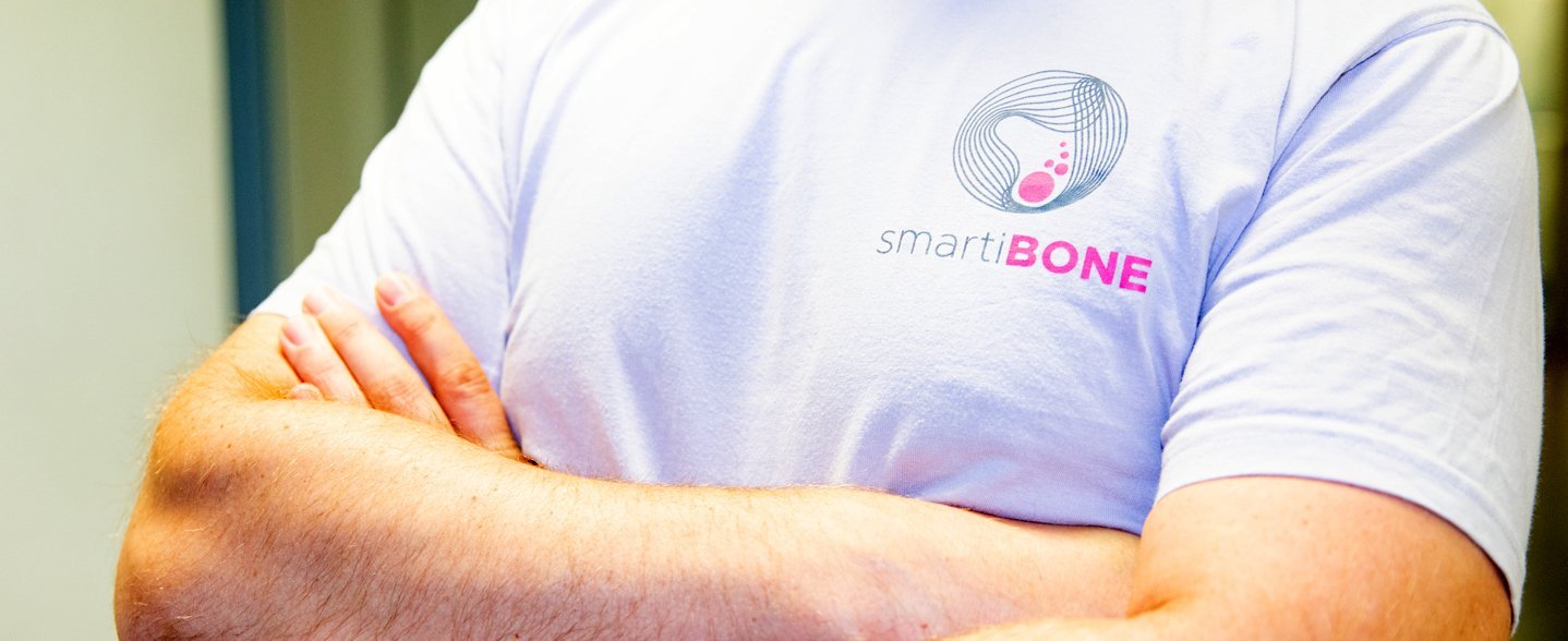 Ein Oberkörper mit verschränkten Armen und smartibone-Shirt
