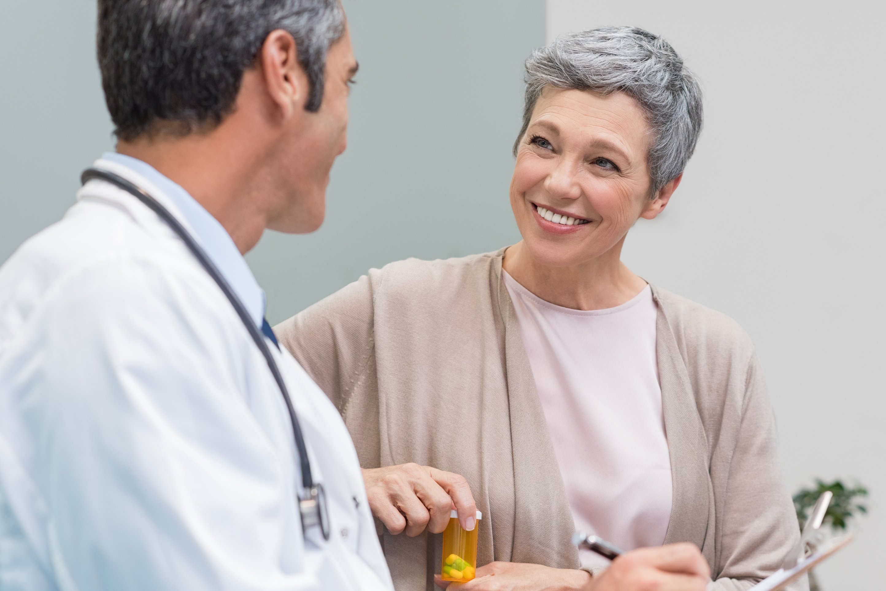 Arzt berät Patientin und verschreibt ihr Medikamente.