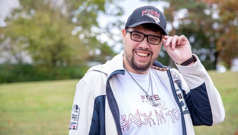 Ein junger Mann mit Sporttrikot und Basecap.