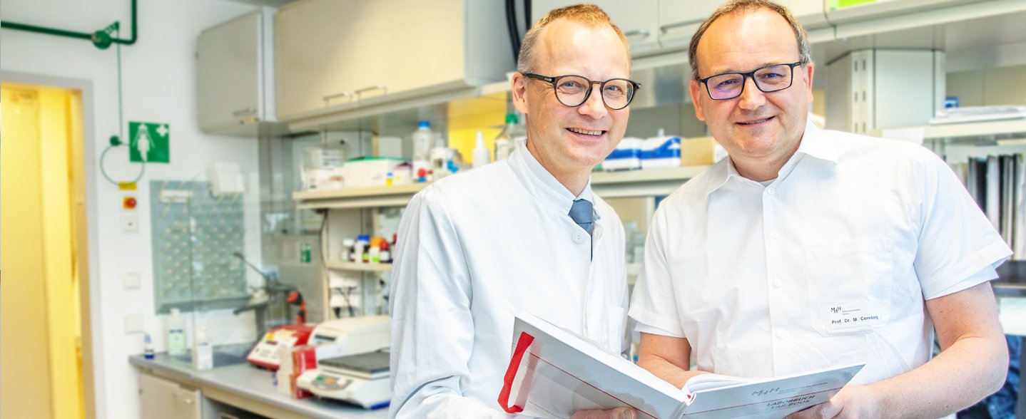 Professor Dr. Heiner Wedemeyer und Professor Dr. Markus Cornberg stehen in einem Labor der MHH-Klinik für Gastroenterologie. 