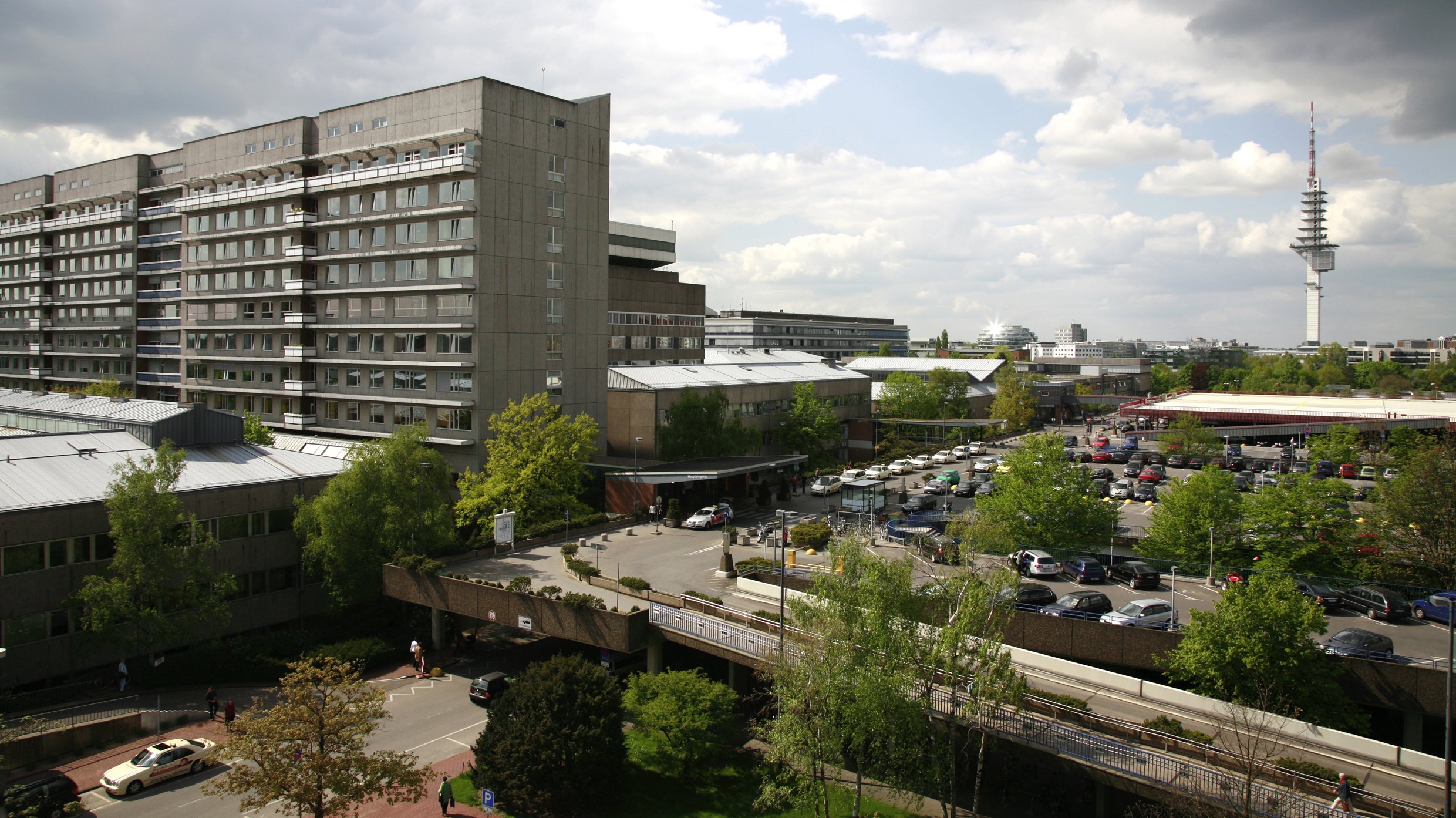 Blick auf das Bettenhaus der MHH mit Parkdeck und umliegenden Gebäuden. 