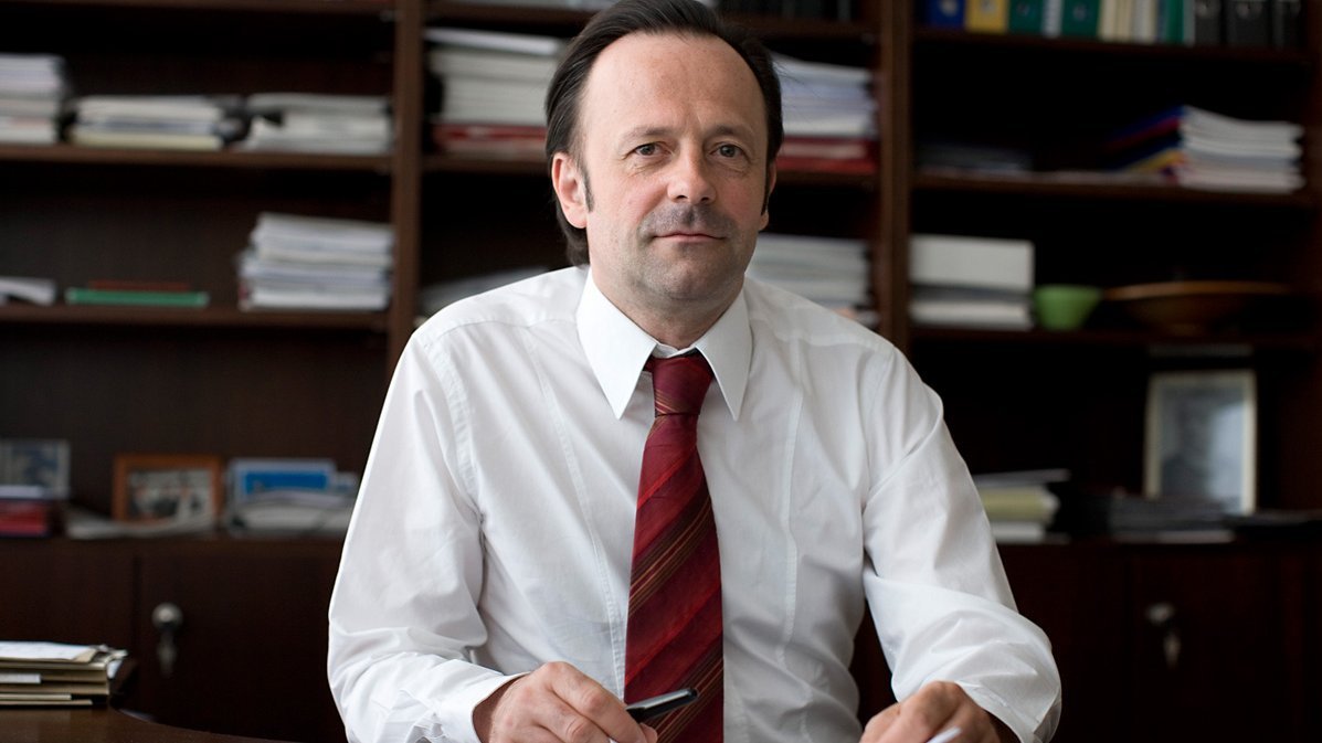 Prof. Dr. med. Joachim K. Krauss sitzt in seinem Büro an einem Schreibtisch. 