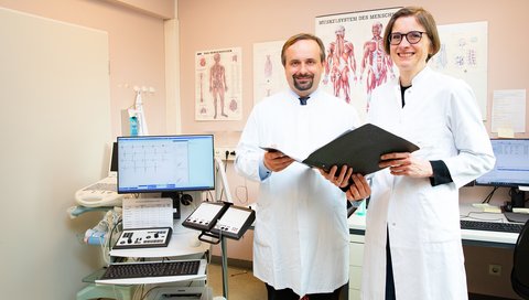  A male and female doctor are standing in an examination room.