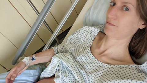 Verena Nabert liegt nach der OP im Krankenhausbett man sieht ihre OP Pflaster auf dem Bauch.
