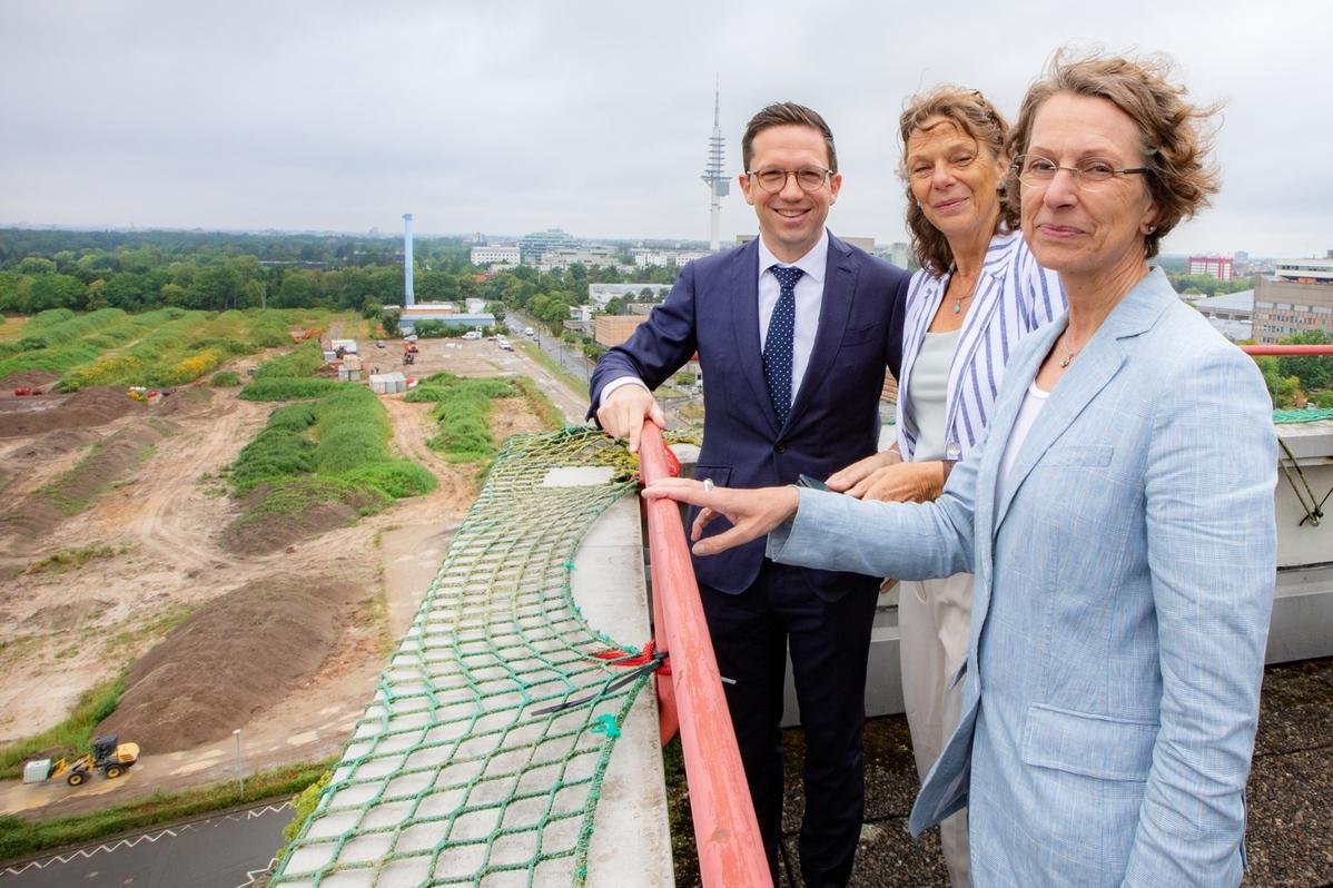 Minister Falko Mohrs, MHH President Prof. Dr. Denise Hilfiker-Kleiner and MHH Vice President Martina Saurin look out over the new construction site from a viewing platform.