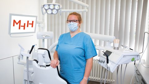 Hannah Deppe sthet im Untersuchungsraum in der Zahnklinik und blickt in die Kamera