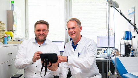 Dr. Matthias Gietzelt and Professor Bavendiek sit next to each other in a cardiology examination room.