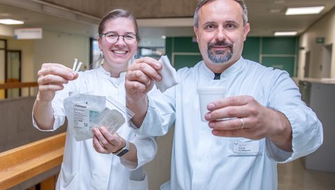 Two doctors are standing in the Department of Neurology holding Schirmer tests and gauze bandages for Sjögren's diagnosis.